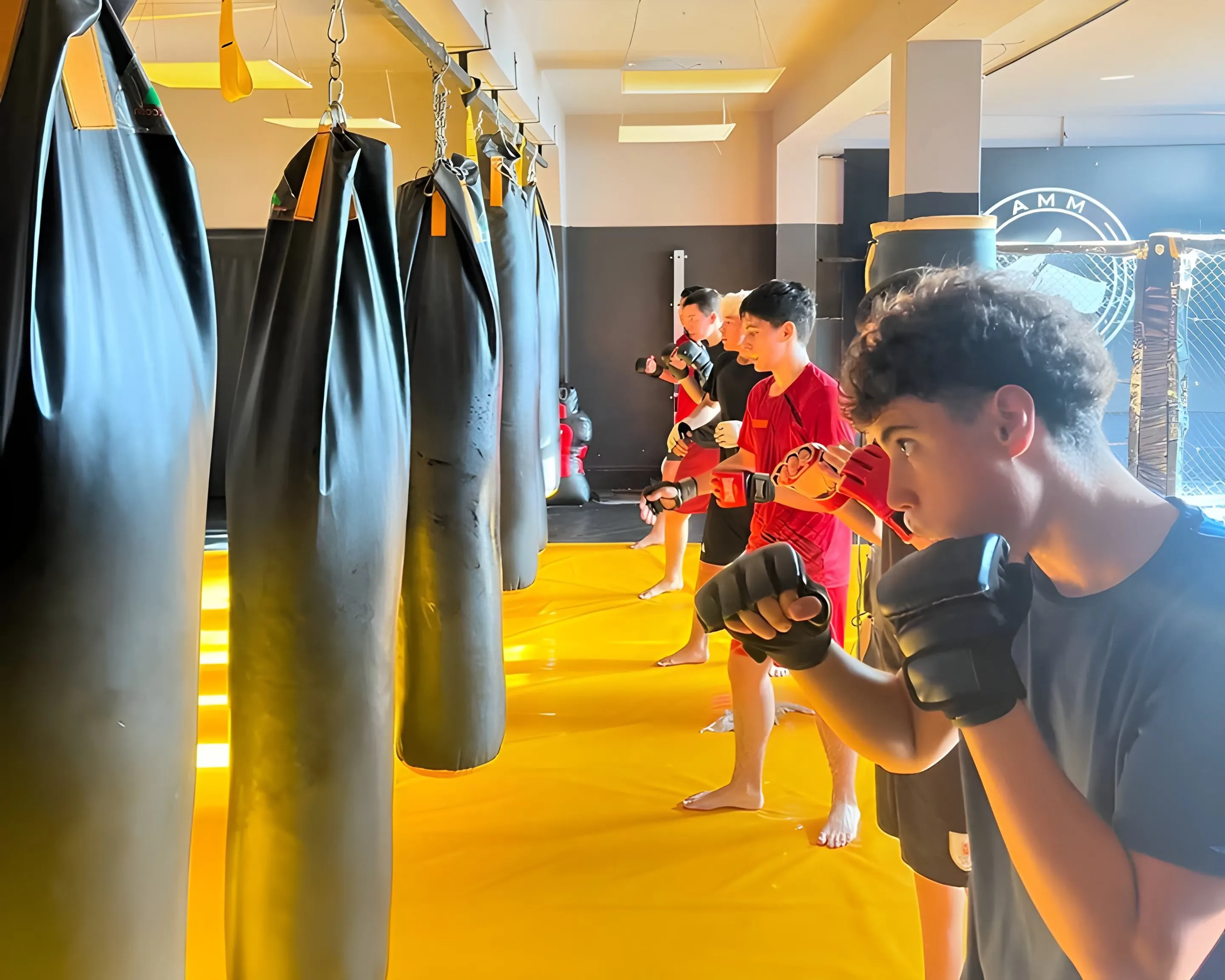 Grupo de adolescentes entrenando artes marciales en un ambiente de crecimiento y superación personal. Los jóvenes están concentrados en sus movimientos, mostrando disciplina y determinación.