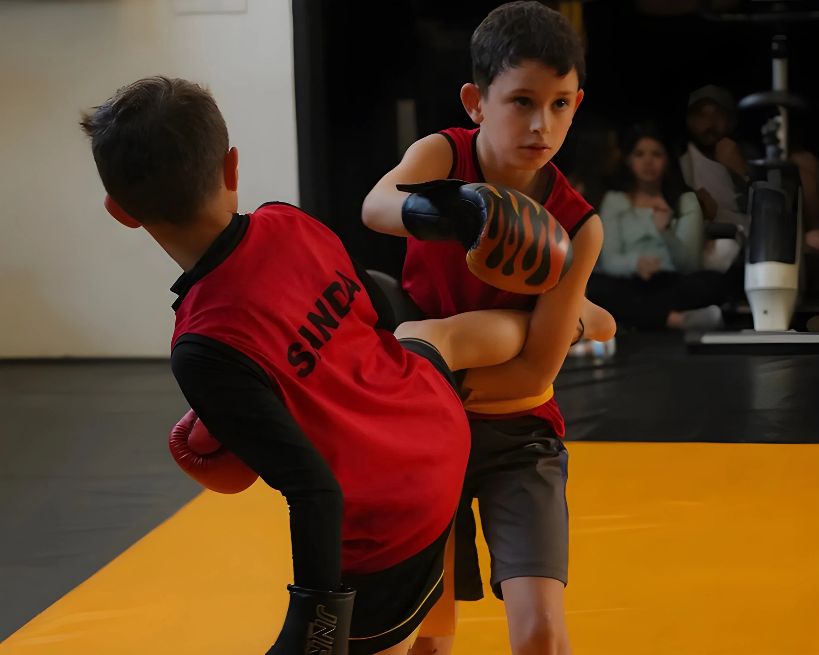 Niños felices entrenando artes marciales en un ambiente seguro y divertido. Los niños están sonriendo mientras practican movimientos básicos, mostrando entusiasmo y alegría.